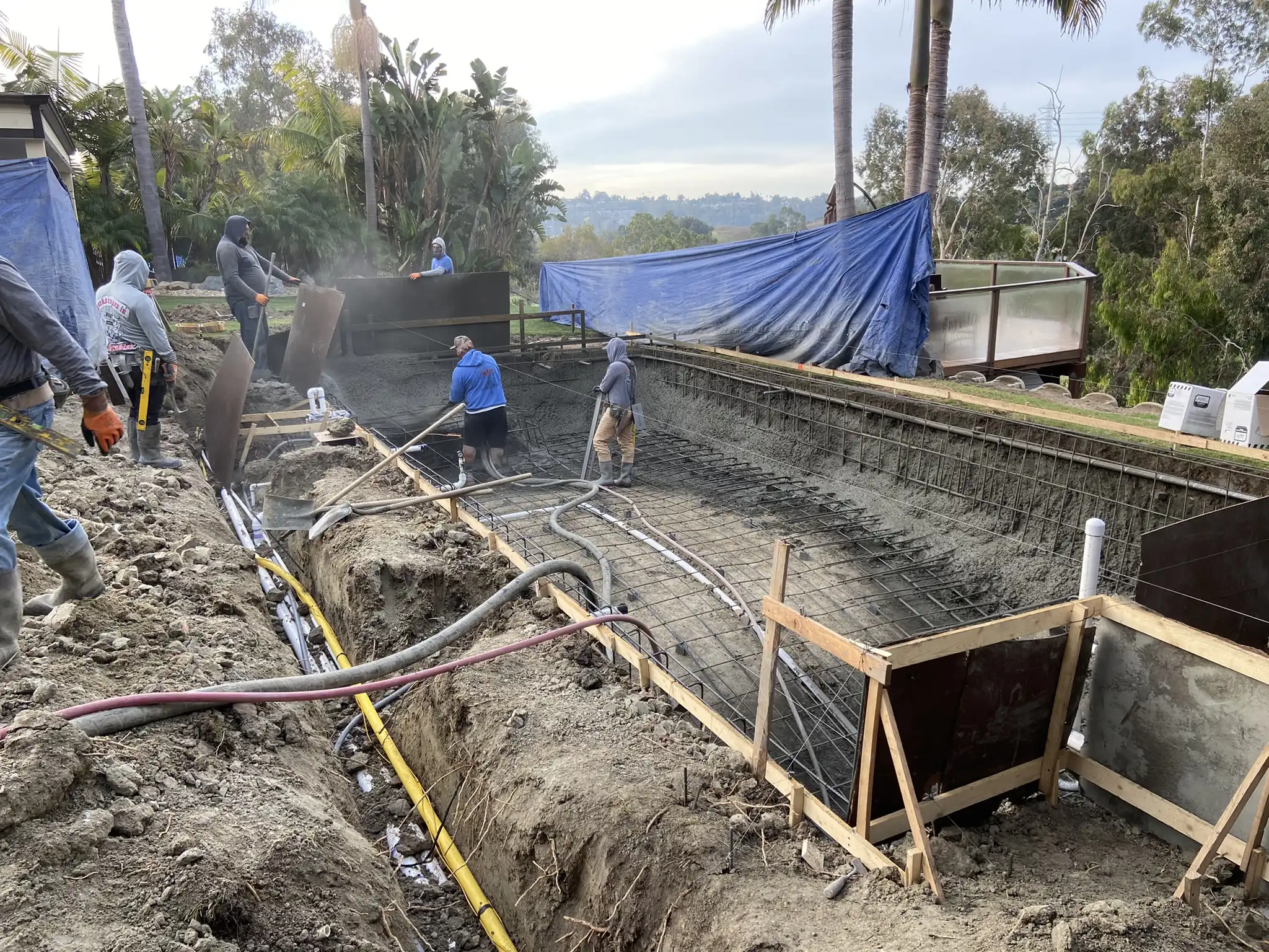 Construction crew building a custom in-ground swimming pool.