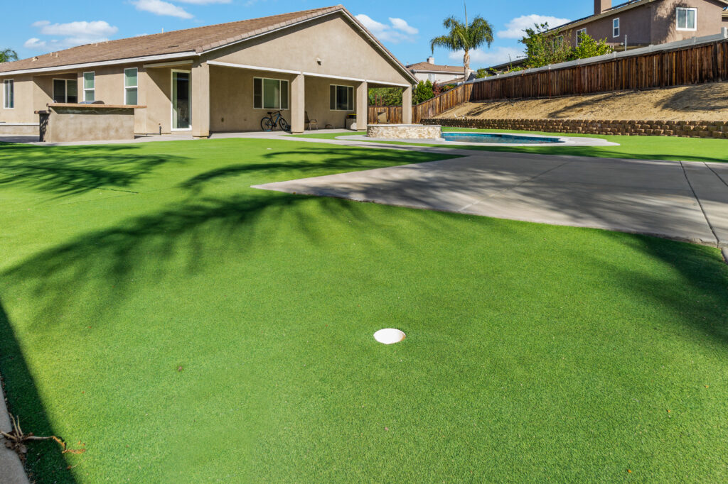 Spacious backyard with turf and pool area.