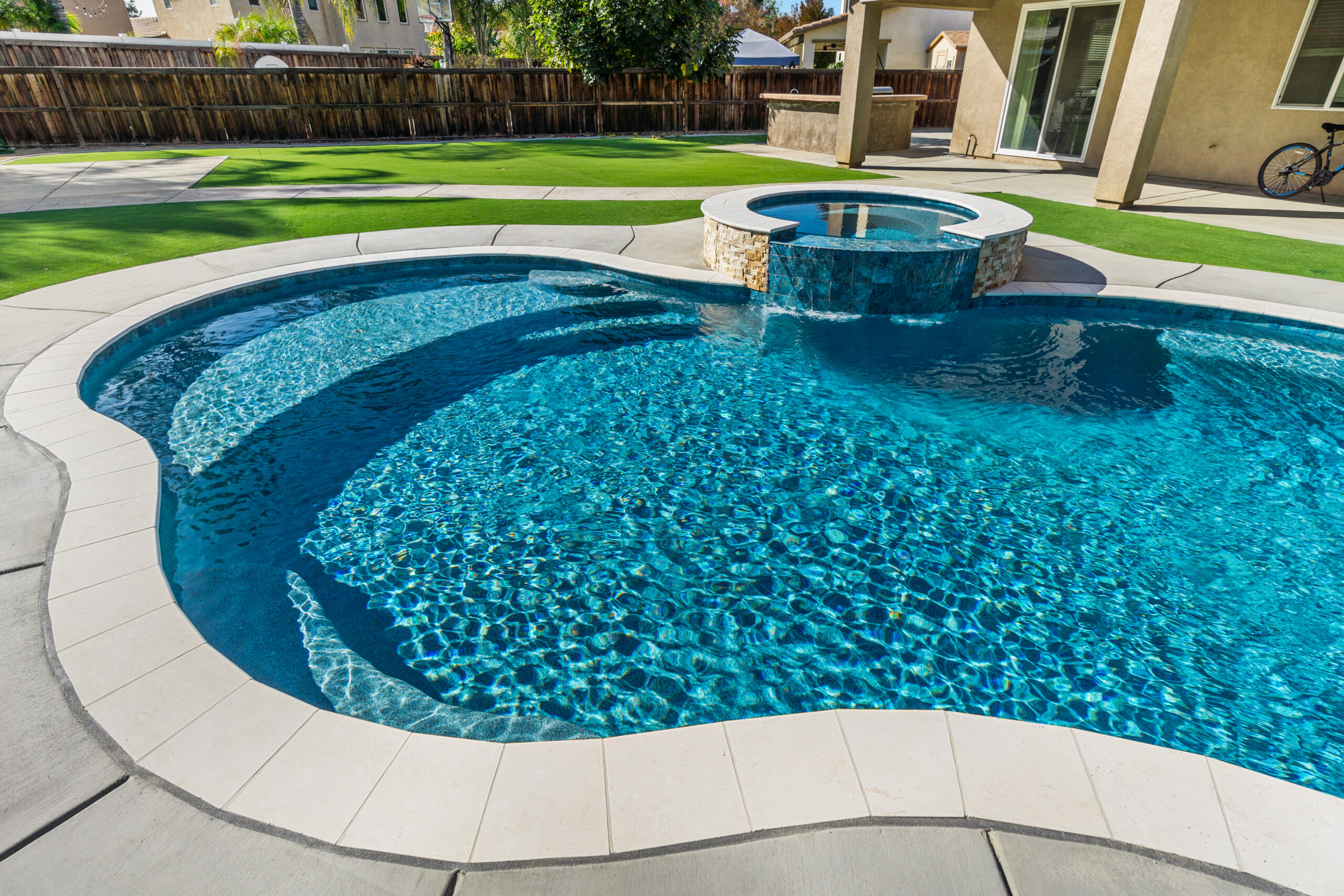 Backyard pool with attached spa and cascading water feature