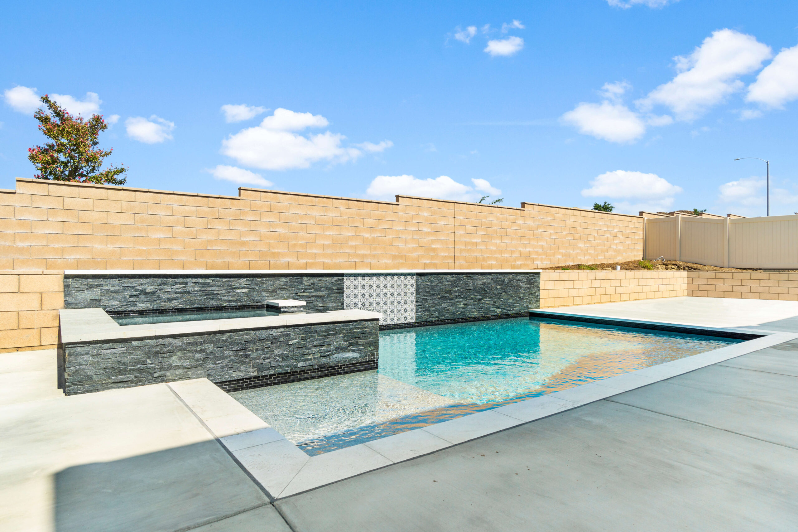 Sleek modern pool with spa by California Custom Pools.