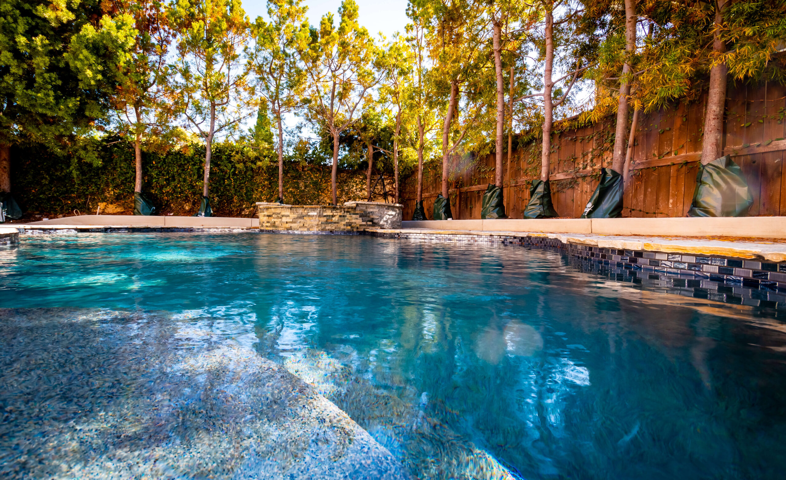 Luxury backyard pool with natural stone accents by California Custom Pools.