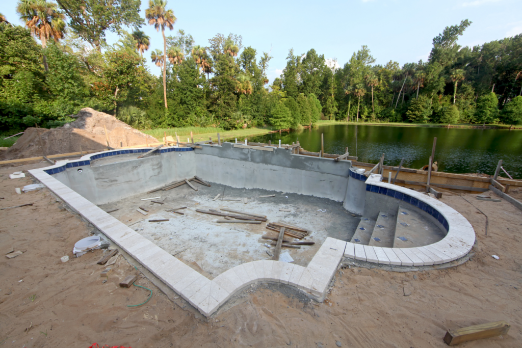 California custom pool under construction near a lake.